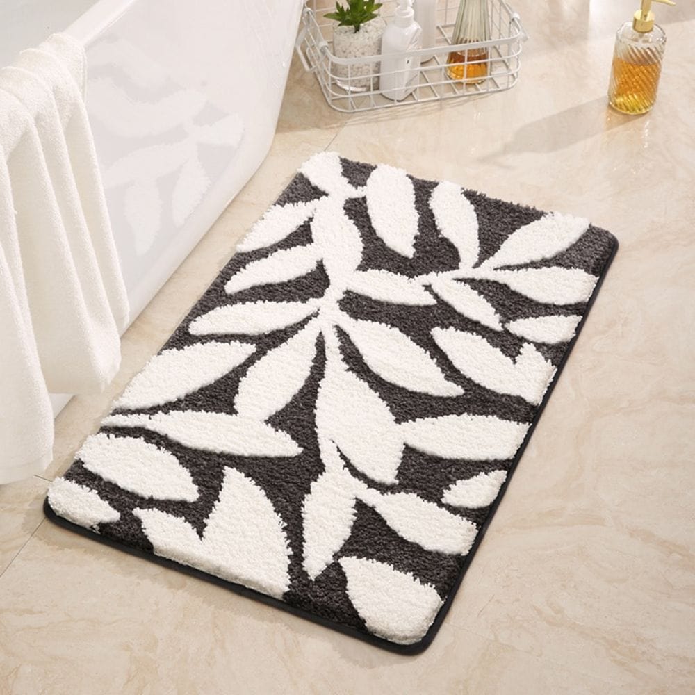 Badmat met bladermotief in zwart-wit, voor badkamer.