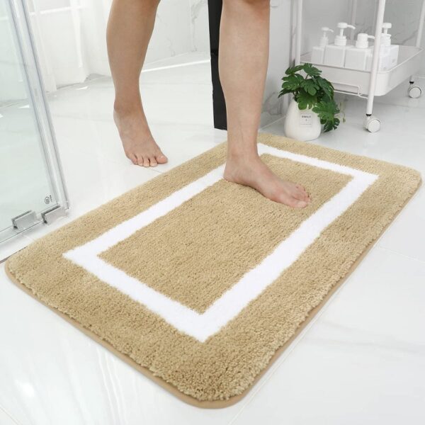 Beige absorberende badkamer mat met witte rand, comfortabel voor voeten.
