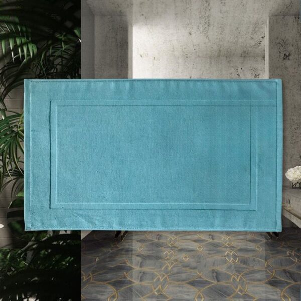 Blauwe katoenen badmat met gestikte rand, modern badkameraccessoire.
