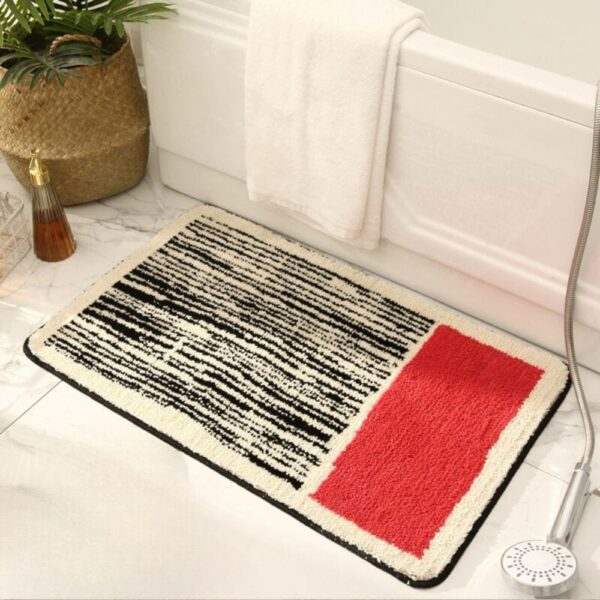 Moderne badmat met zwart-wit strepen en rode accent, voor badkamer.