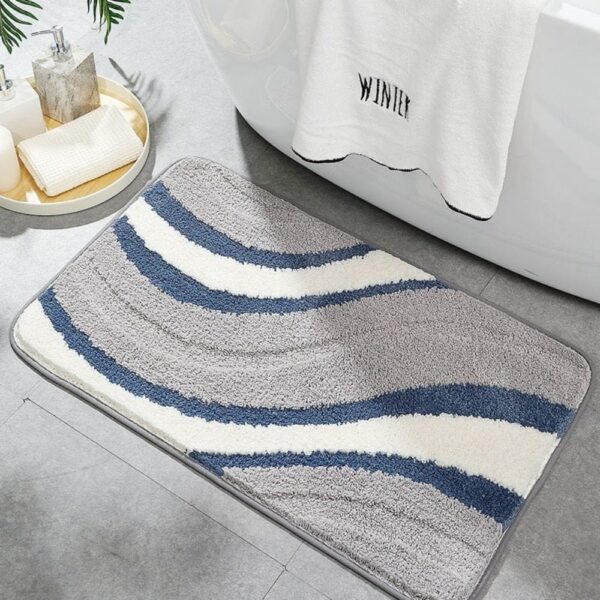 Originele grijs-witte badmat met blauwe golven, perfect voor moderne badkamer.
