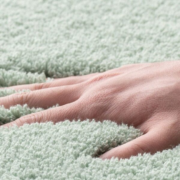 Zachte badmat met antislip eigenschap, groen, handen aanraken.