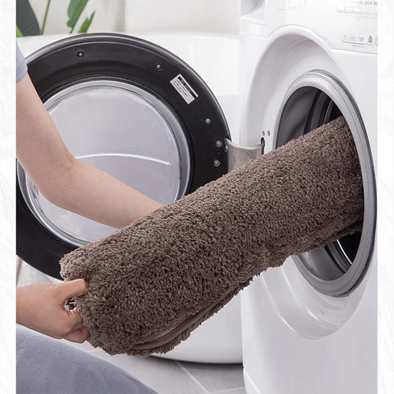 Bruine badmat in wasmachine voor gemakkelijke wasbeurt.