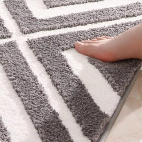 Gestreepte badmat met grijze en witte strepen voor badkamer decoratie.