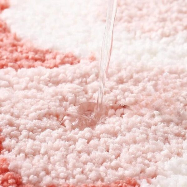 Badmat met roze en witte kleuren, water wordt opgevangen.