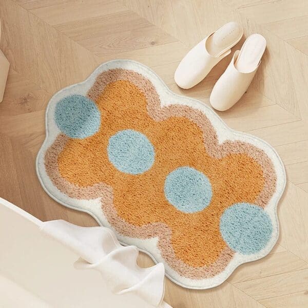 Oranje badkamer tapijt met blauwe cirkels en witte rand.