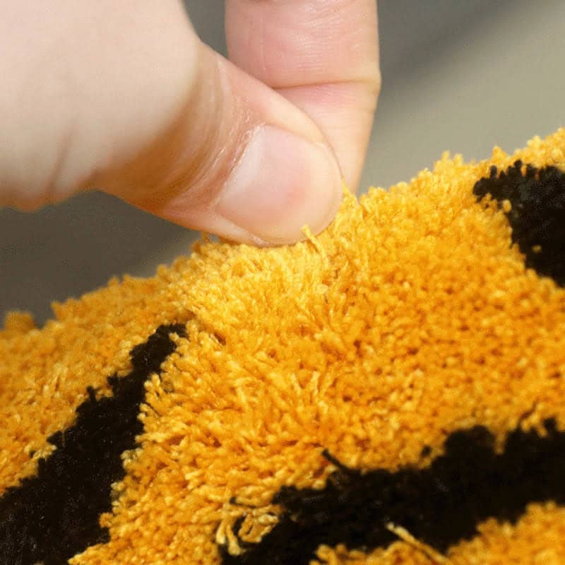 Originele vorm badmat met fluweelachtige textuur en oranje-zwarte kleuren.