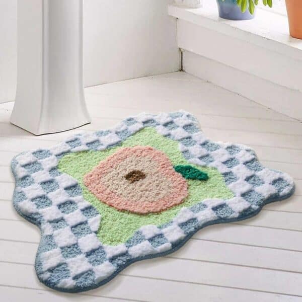 Perzikkunst badmat met roze perzik op groen en blauw geruit patroon.