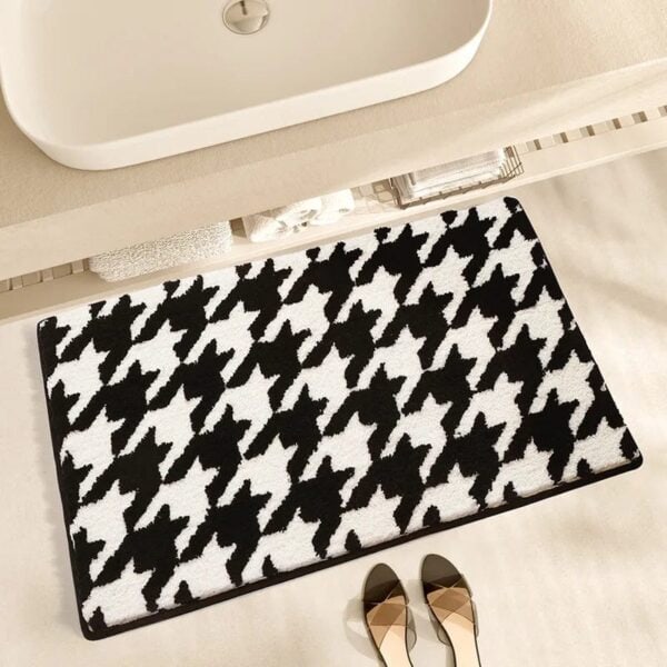 Zwart-wit houndstooth badkamer tapijt onder wastafel.