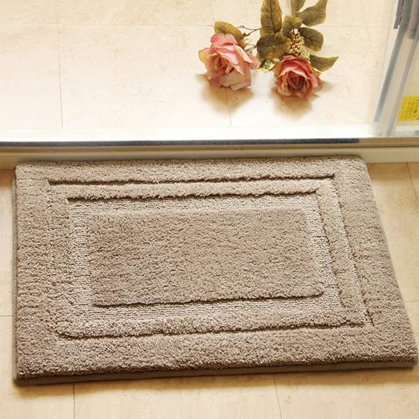 Absorbent bath mat with textured border for bathroom.