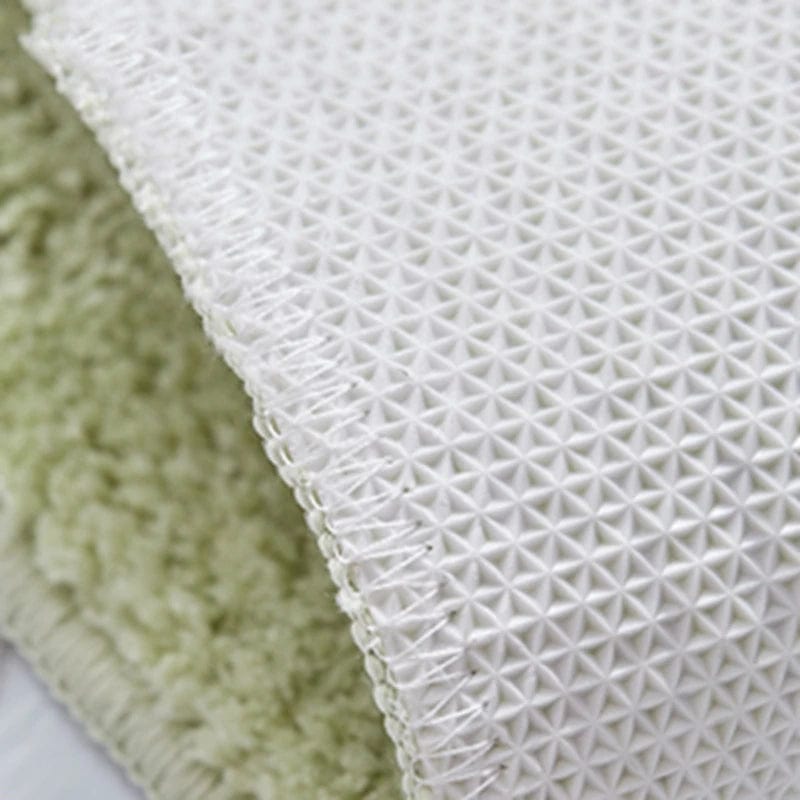 Avocado colored bath mat with textured white backing for non-slip safety.