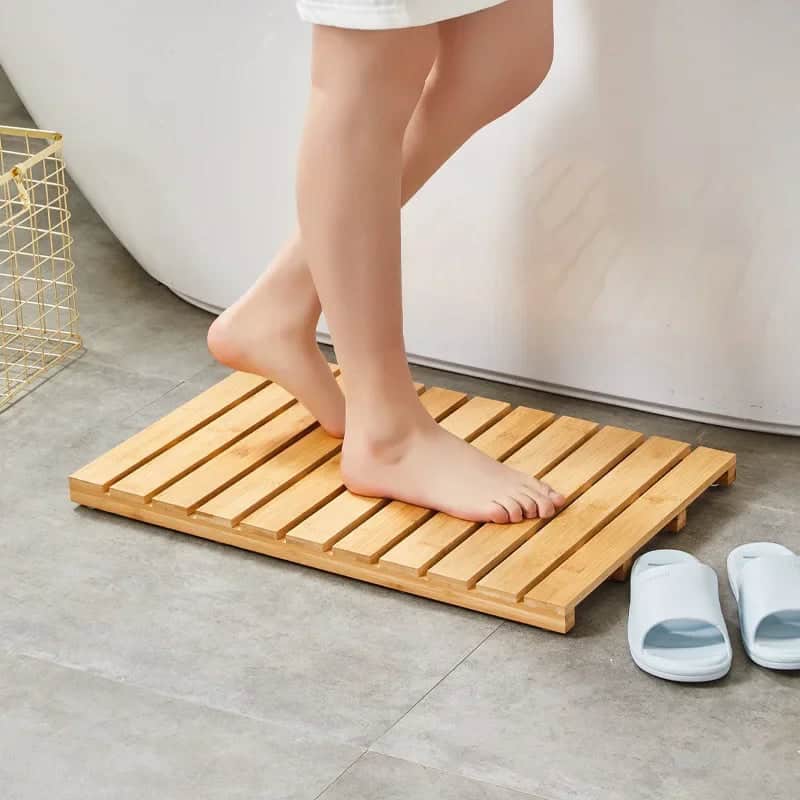 Bamboo slatted bath mat for comfort and drainage.