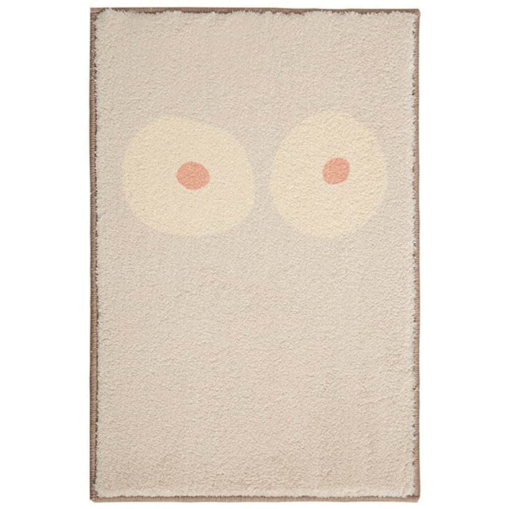 Abstract owl eyes bath mat with soft beige and peach tones.