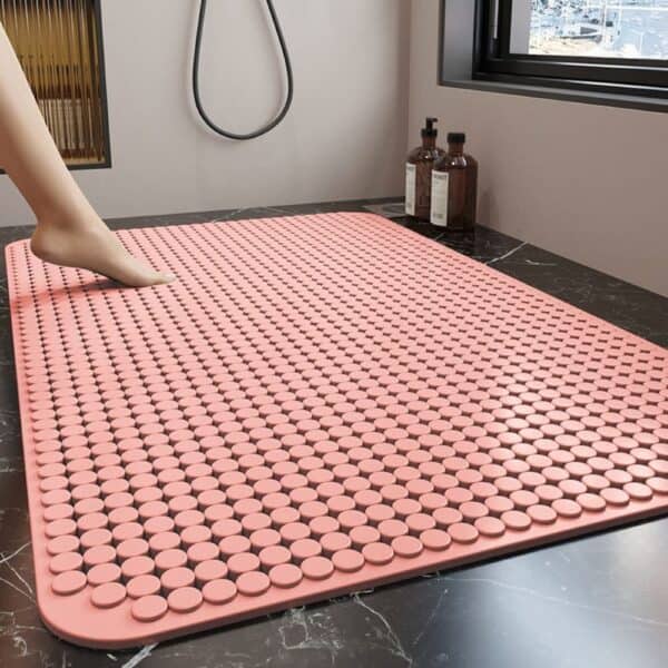 Pink textured bath mat for shower floor, non-slip design.