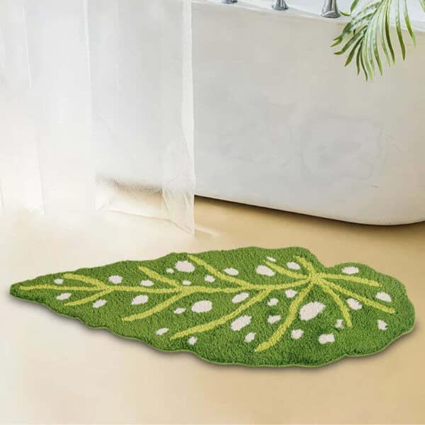 Green leaf-shaped bath mat with white dots for bathroom decor.