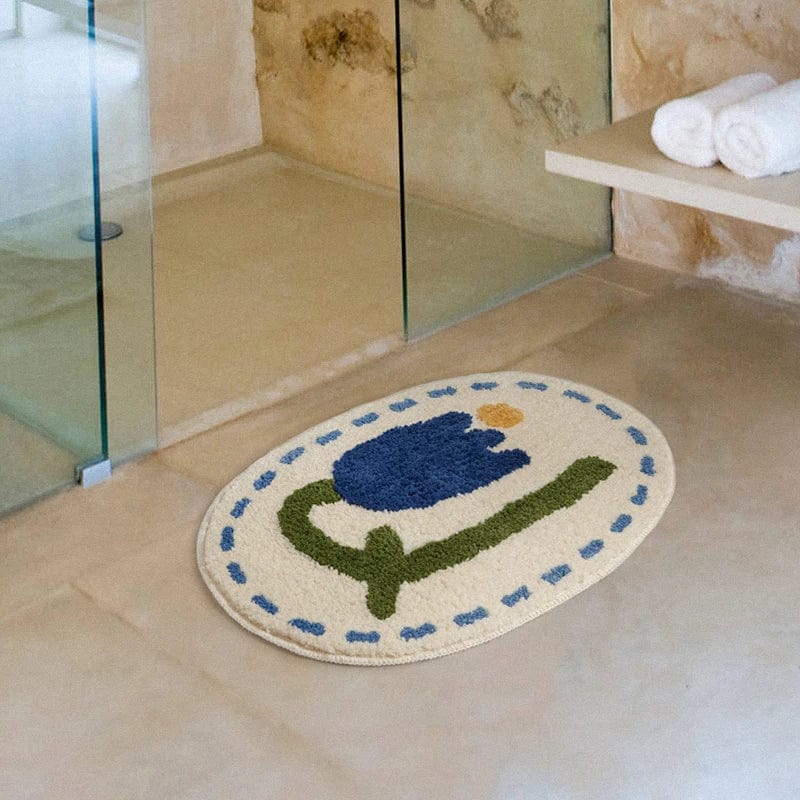Round bath mat with blue tulip design for bathroom.