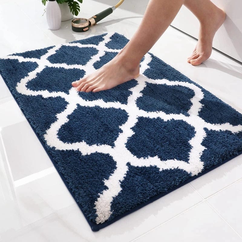 Blue and white Berber bath mat with geometric pattern, foot stepping on it.