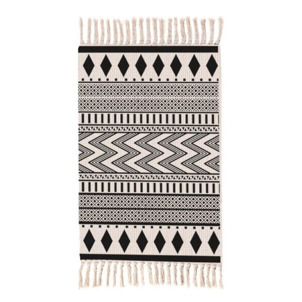 Black and white patterned bath mat with fringe detailing.