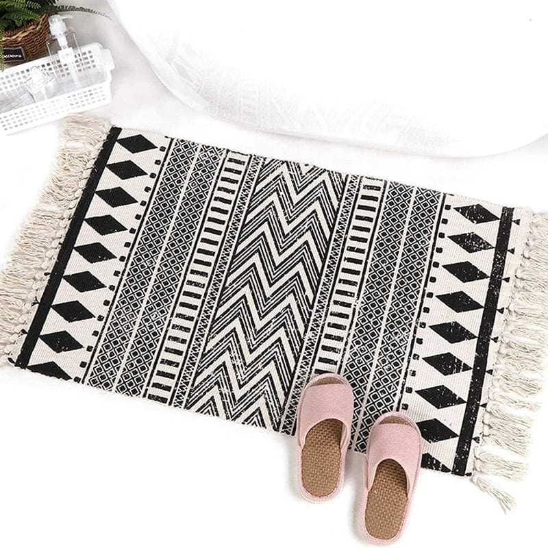 Black and white patterned bath mat with fringe, stylish bathroom decor.