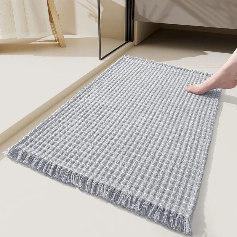 Boho style grey bath mat with fringe, cozy bathroom rug.