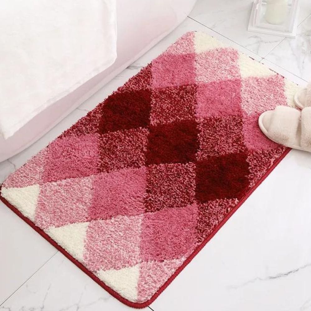 Pink and red checked plush bath mat for bathroom.