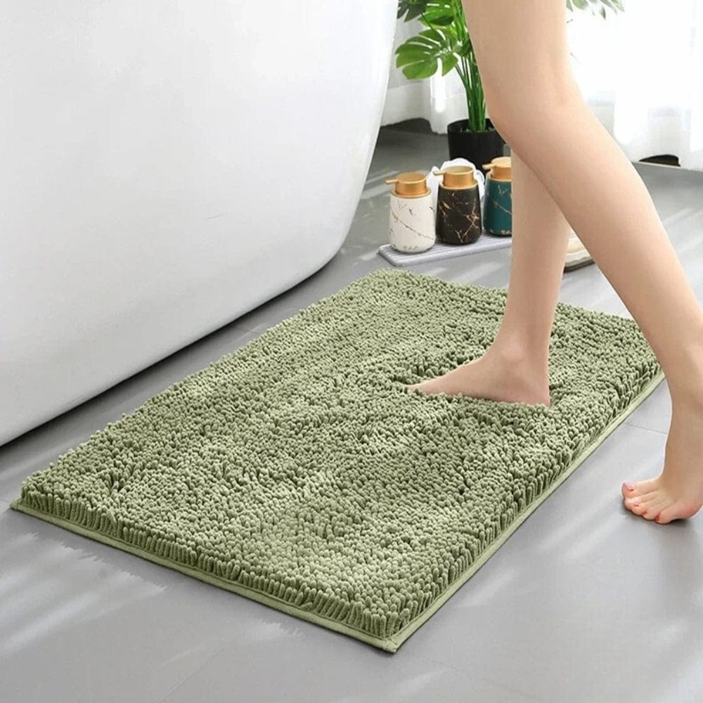 Soft green chenille bath mat for comfort and style.