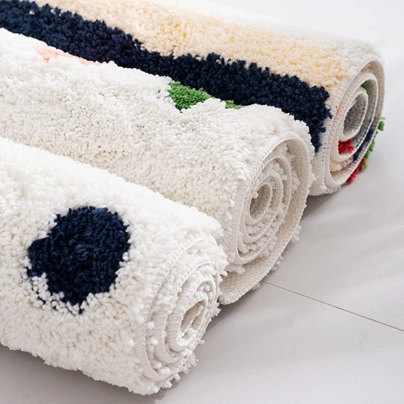 Colourful bath mats rolled up, soft fluffy texture, bathroom rug options.