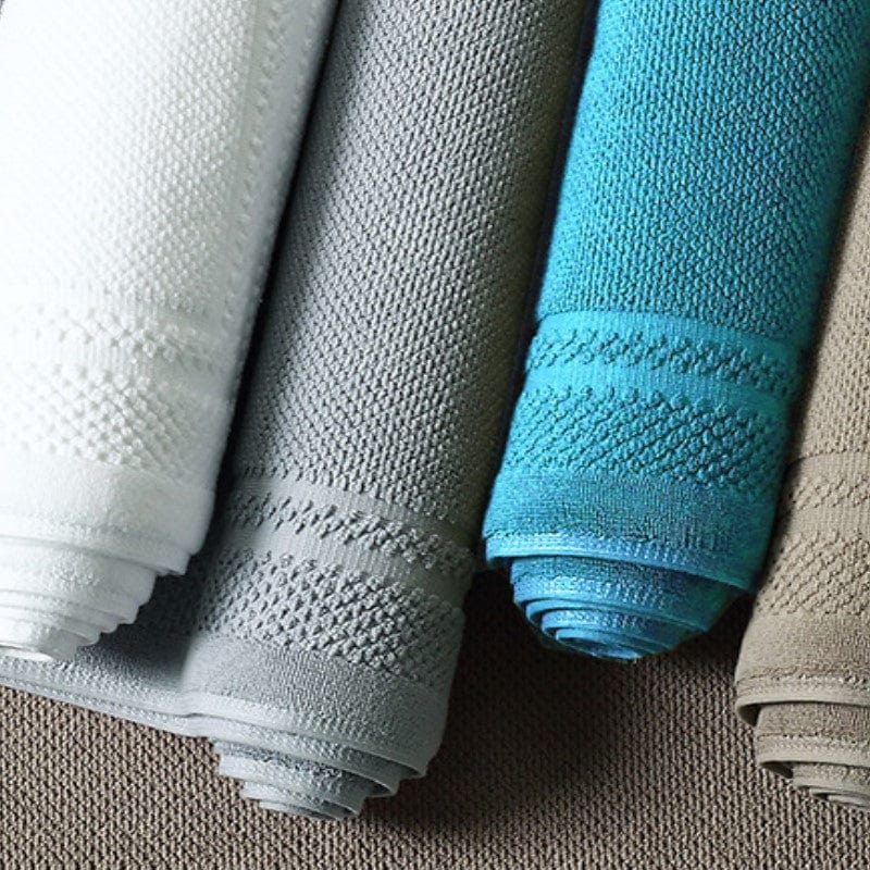 Cotton bath mat towel rolls in white, grey, blue and beige colors.