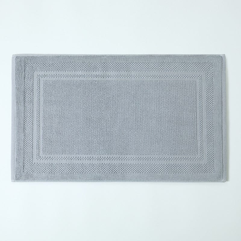 Gray cotton bath mat towel with textured border design.