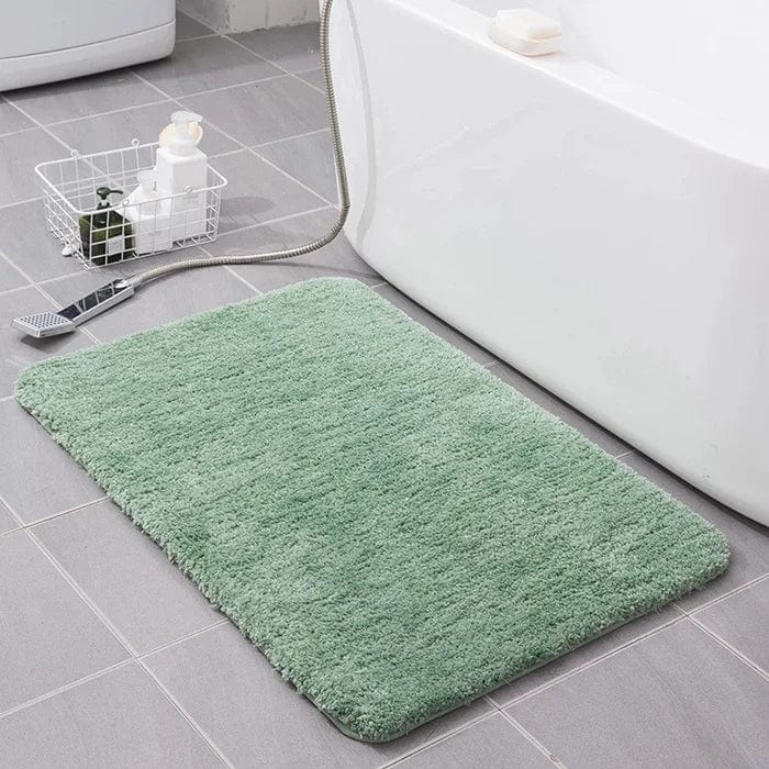 Soft green fluffy bath mat beside white bathtub for cozy bathroom.