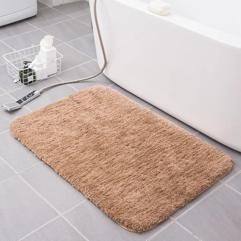 Soft fluffy beige bath mat beside white bathtub for cozy bathroom comfort.