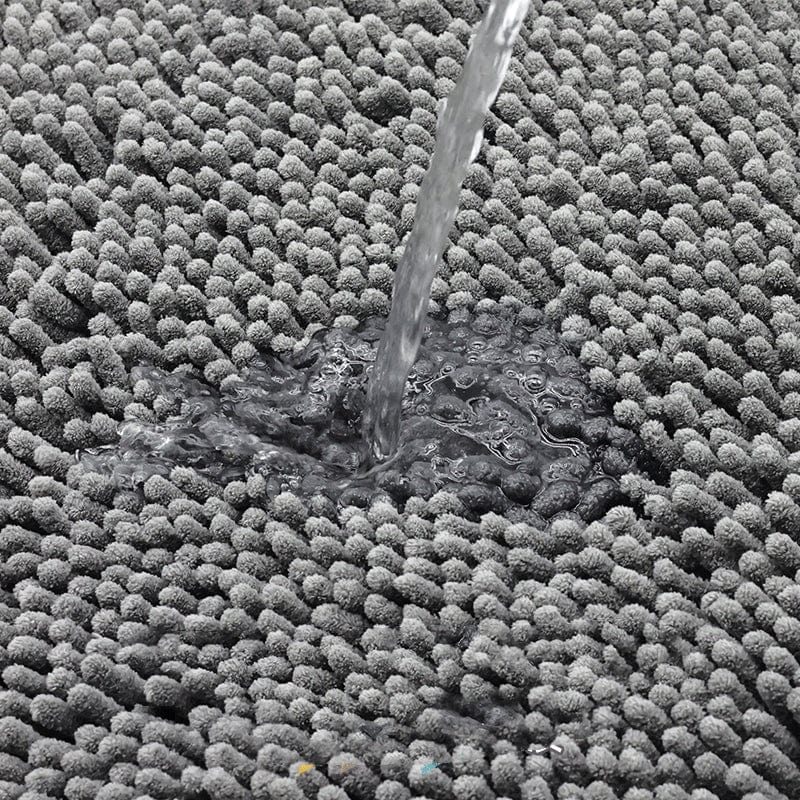 Dark green bath mat absorbing water quickly.