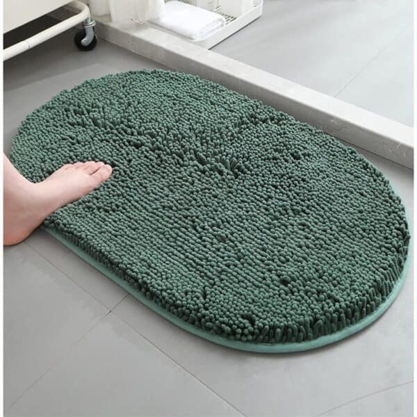 Dark green fluffy bath mat with foot stepping on it for comfort and style.