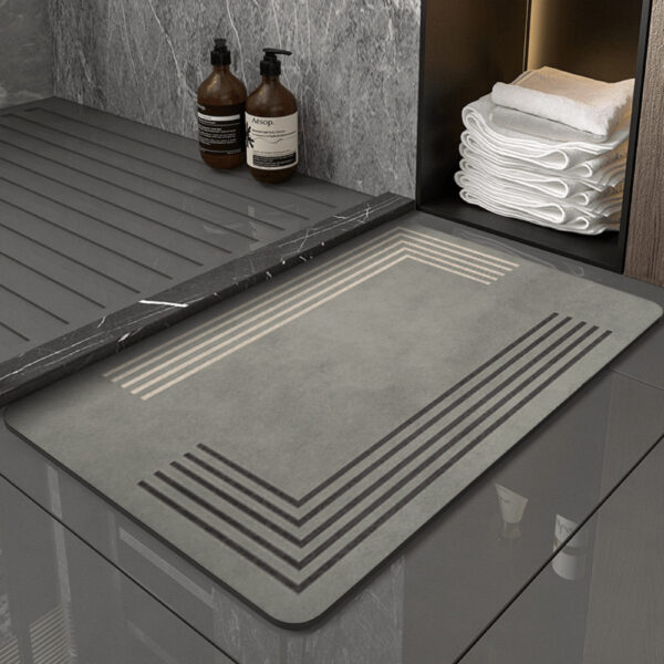 Grey diatomite bath mat with geometric stripes for modern bathroom.