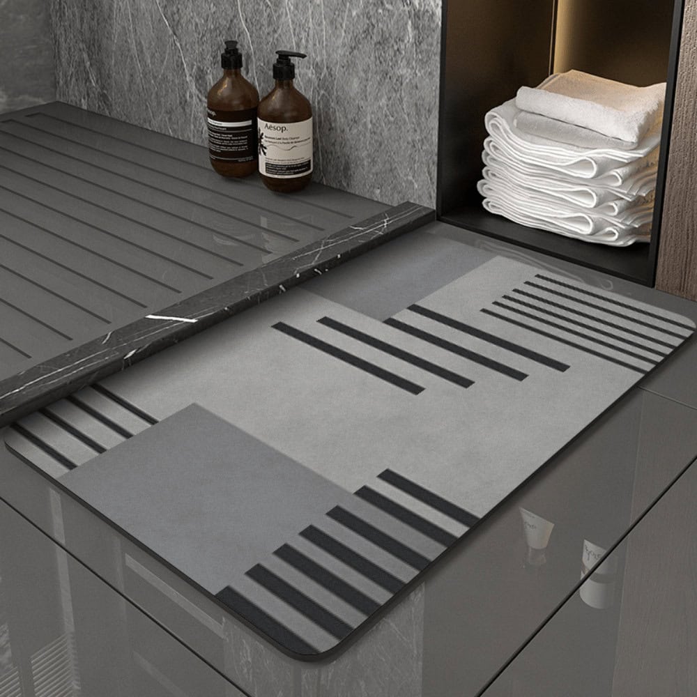 Grey diatomite bath mat with striped pattern for modern bathroom.