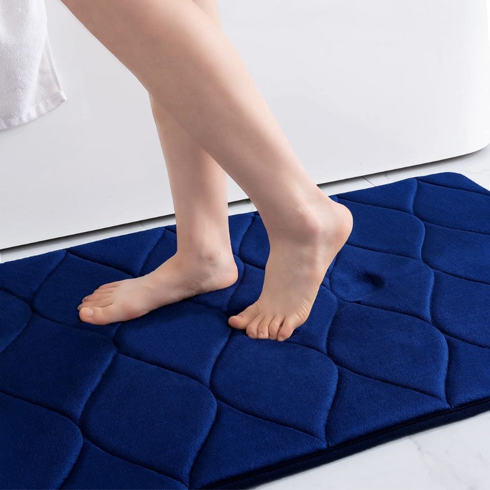 Extra thick navy blue bath mat with quilted texture for comfort and grip.