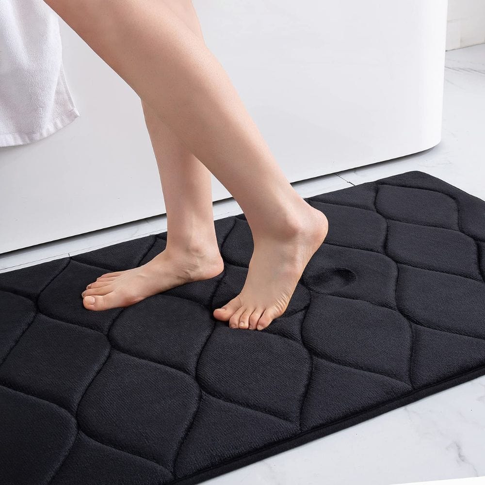 Extra thick black bath mat with quilted design for comfort and non-slip bathroom use.