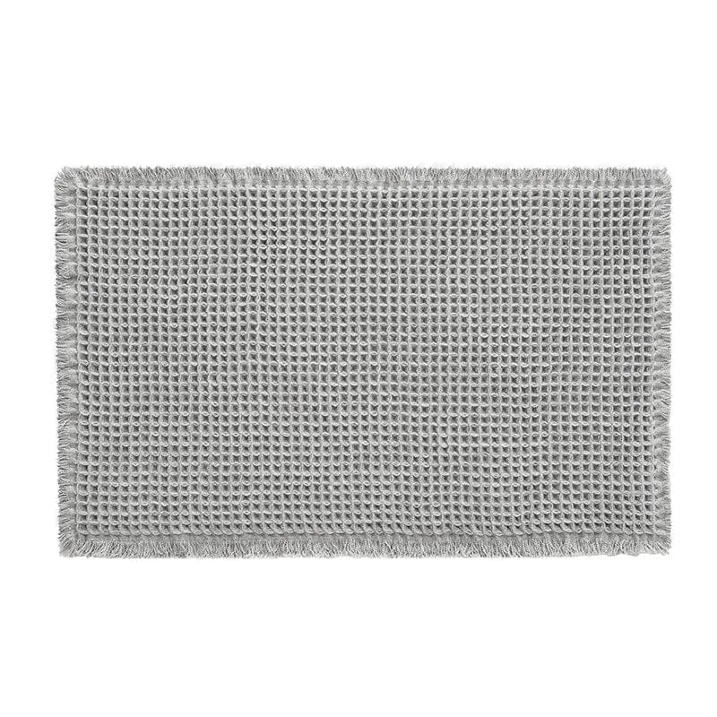 Gray flat weave bath mat with fringed edges for bathroom.