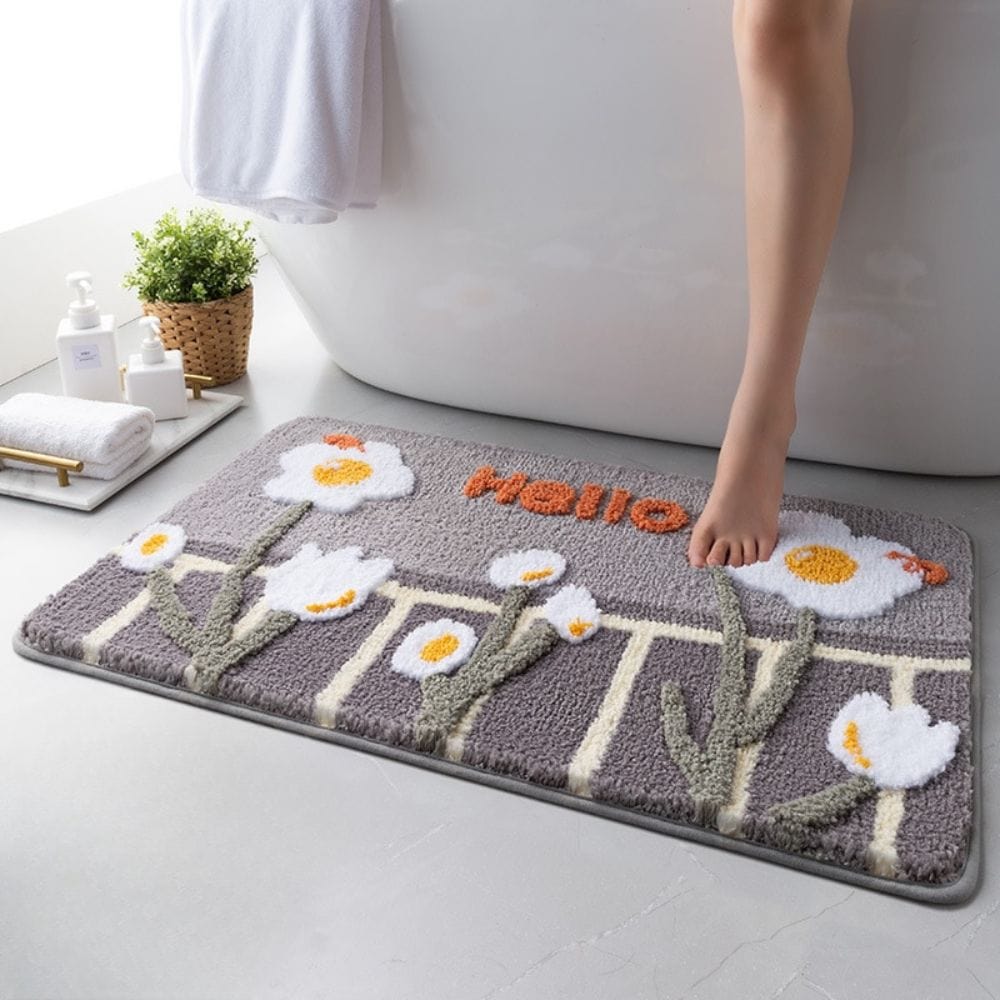 Floral bath mat with daisies and 'Hello' text, cozy bathroom decor.