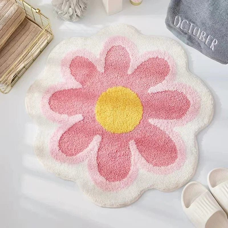 Flower shaped bath mat with pink petals and yellow center.