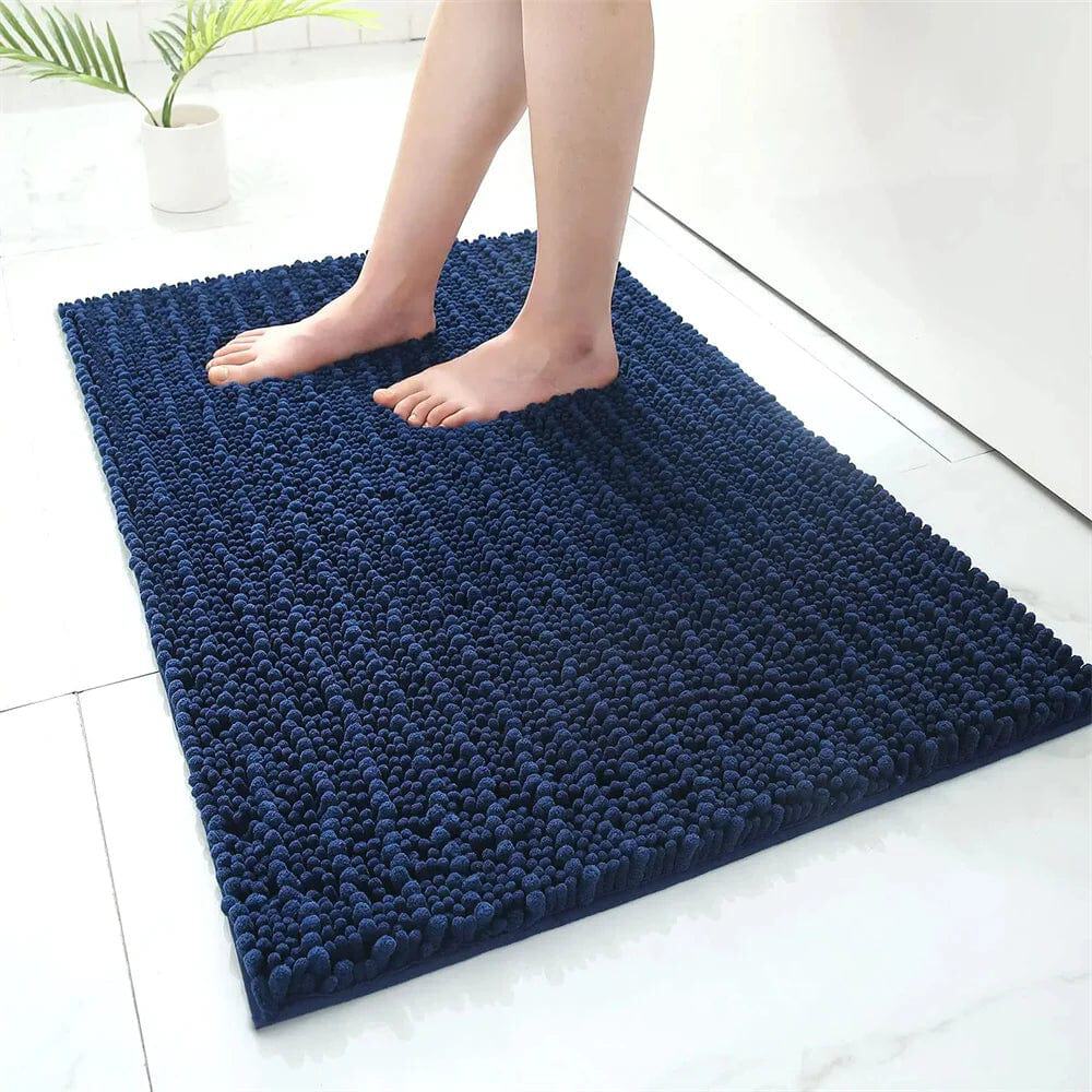 Fluffy navy blue bath mat with textured loops, feet stepping on it.