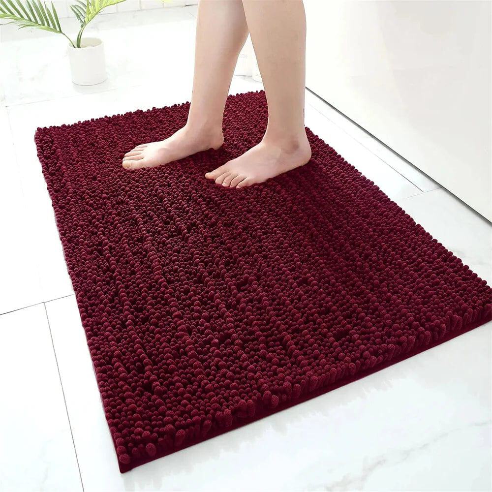 Fluffy burgundy bath mat with textured pom-pom design for cozy bathroom comfort.