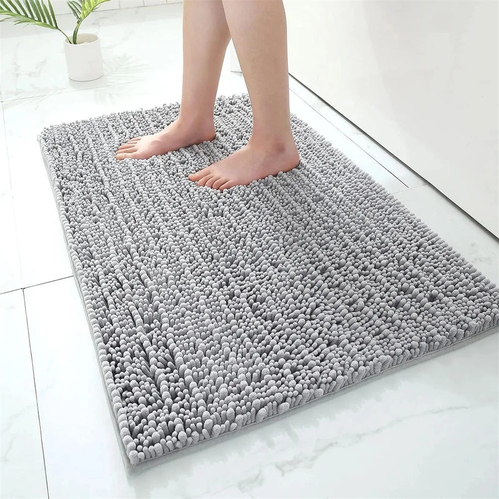 Fluffy grey bath mat with textured loops, bare feet stepping on it in modern bathroom.