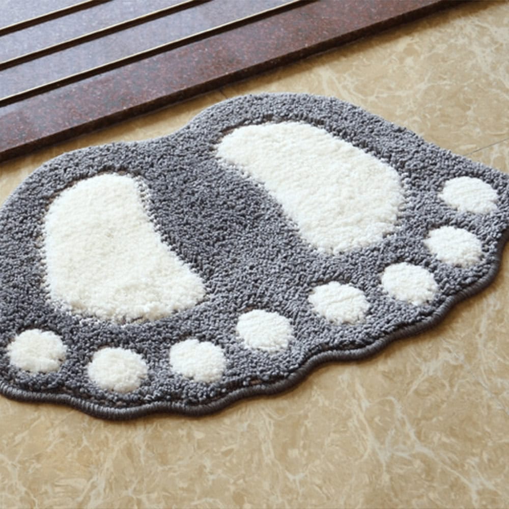 Foot shaped bath mat with grey and white plush design for bathroom comfort.