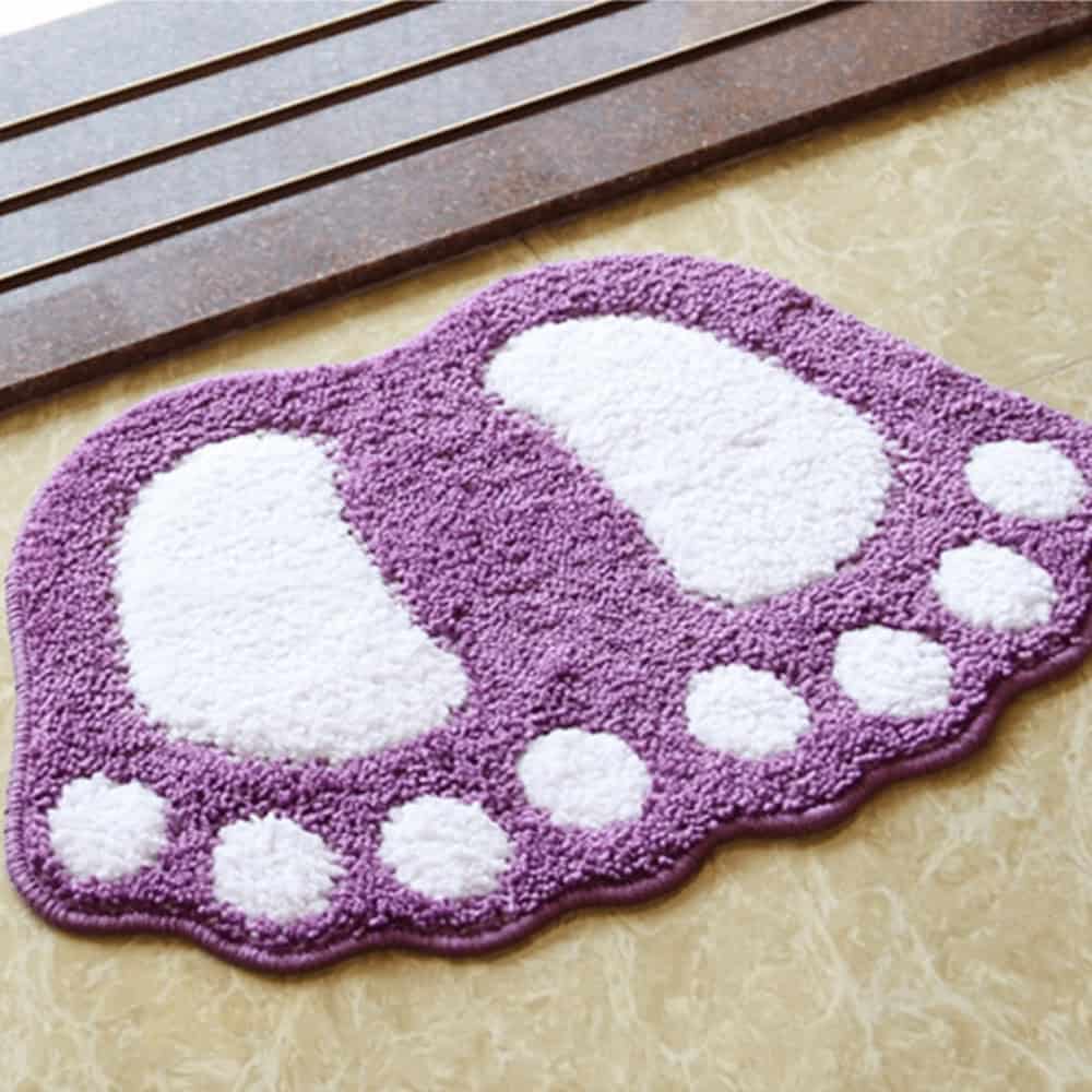 Purple foot-shaped bath mat with white toe and heel accents.