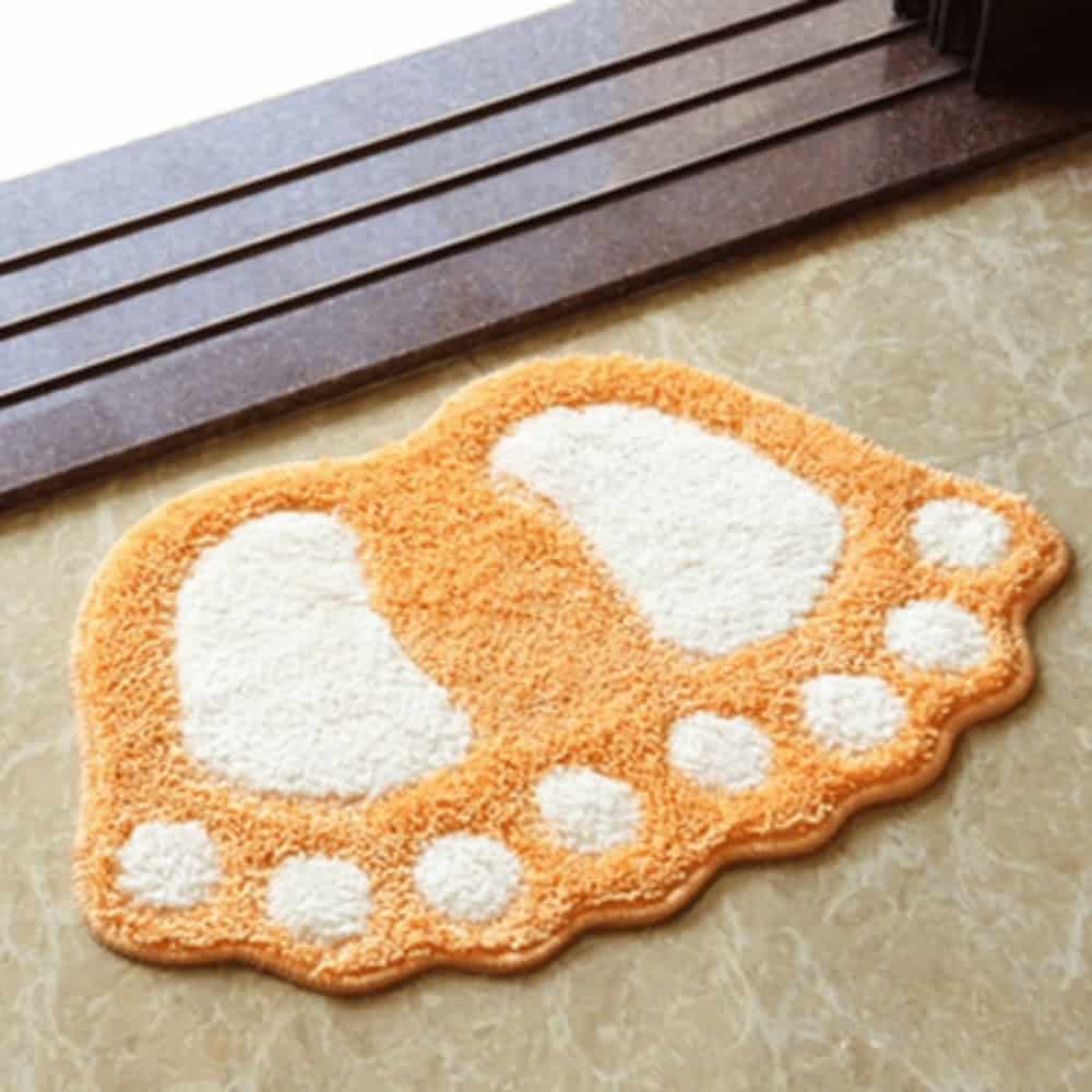 Foot shaped bath mat orange and white fluffy design.