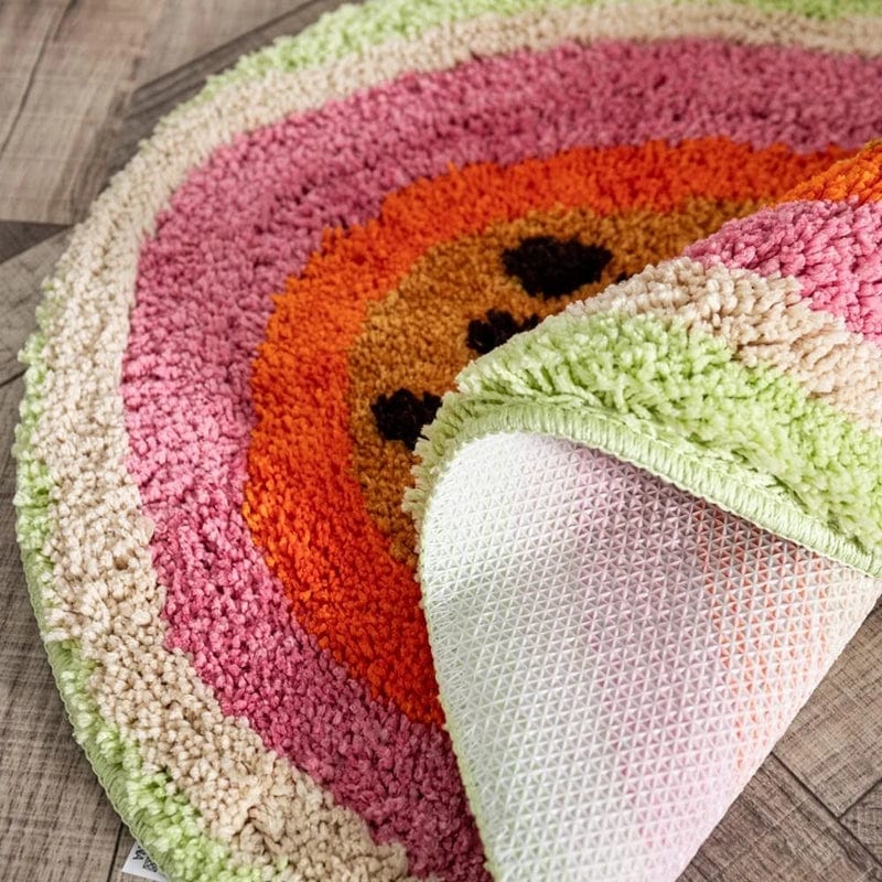 Fruit shaped bath mat with colorful rainbow design and textured non-slip backing.