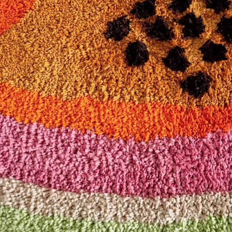 Fruit shaped bath mat with colorful layered design.