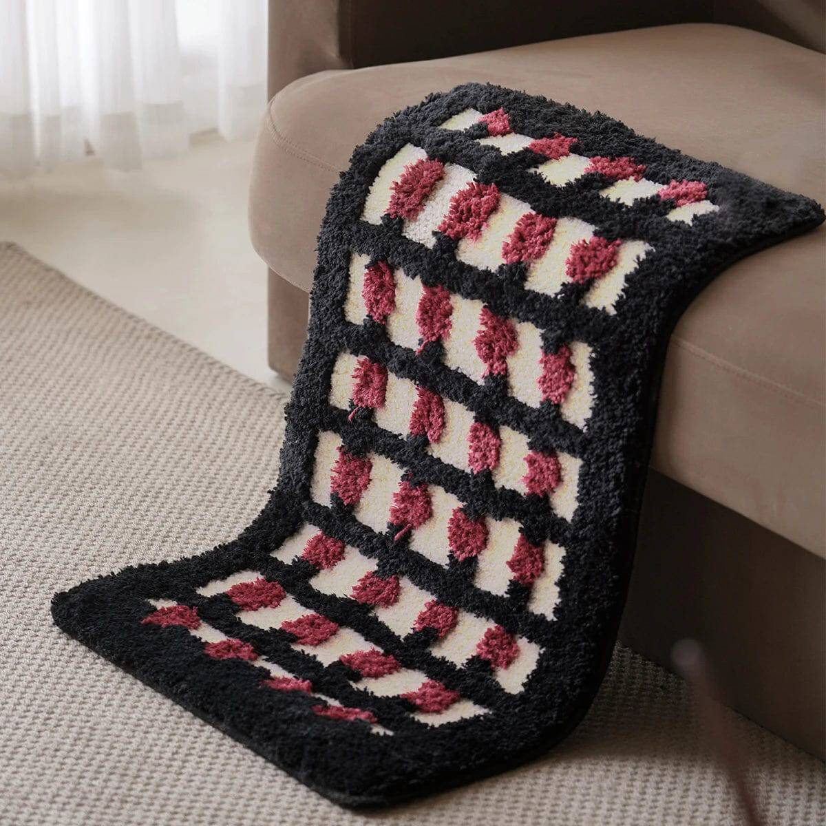 Geometric bath mat with black, white, and pink shaggy pattern.