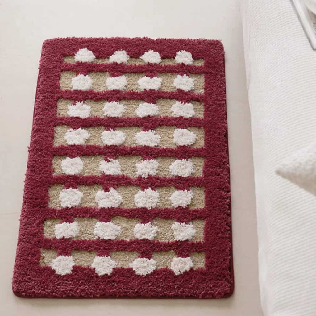 Geometric bath mat with red border and white dot pattern.